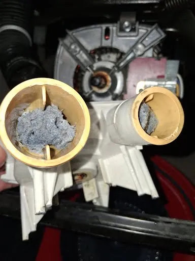 Washing machine pump housing clogged with lint and debris